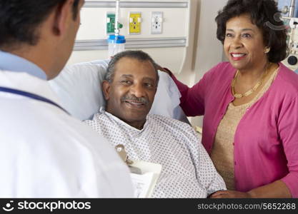 Doctor Talking To Senior Couple On Ward