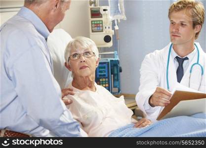 Doctor Talking To Senior Couple On Ward