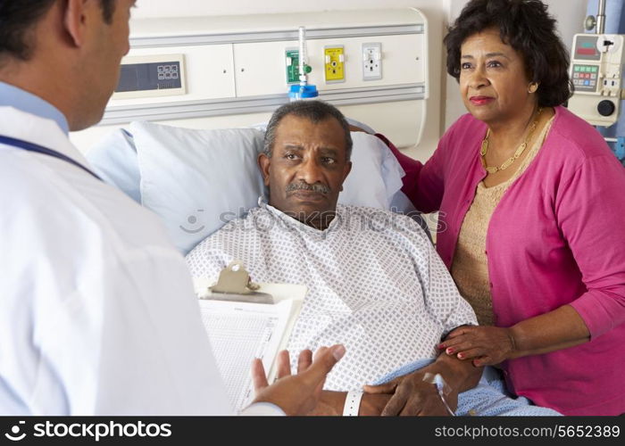 Doctor Talking To Senior Couple On Ward