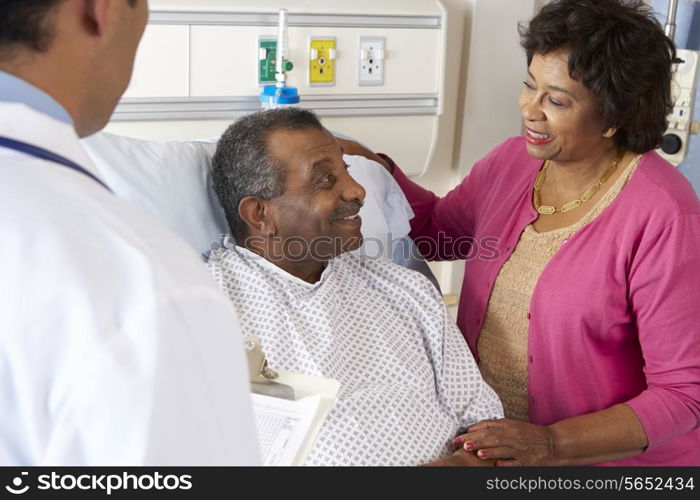 Doctor Talking To Senior Couple On Ward