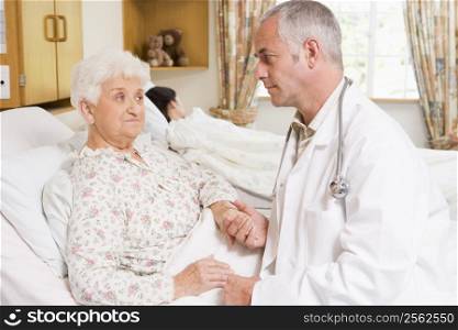 Doctor Talking With Senior Woman Patient In Hospital