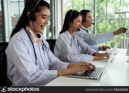 Doctor team wearing headset talking actively on video call in hospital clinic . Concept of telehealth and telemedicine service .. Doctor team wearing headset talking actively on video call in hospital clinic