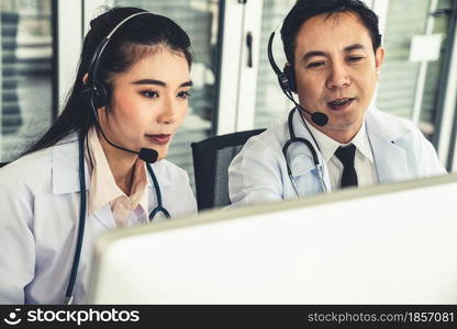 Doctor team wearing headset talking actively on video call in hospital clinic . Concept of telehealth and telemedicine service .. Doctor team wearing headset talking actively on video call in hospital clinic