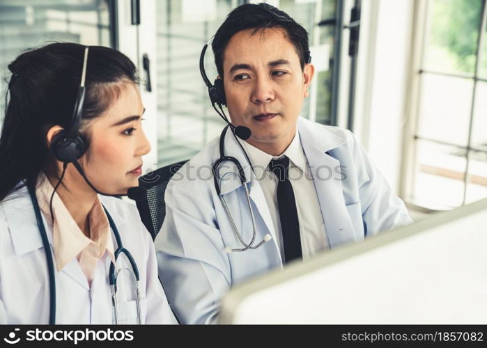 Doctor team wearing headset talking actively on video call in hospital clinic . Concept of telehealth and telemedicine service .. Doctor team wearing headset talking actively on video call in hospital clinic