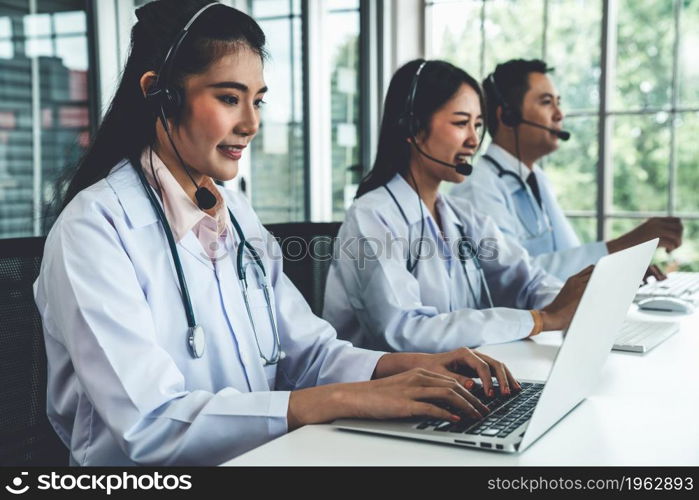 Doctor team wearing headset talking actively on video call in hospital clinic . Concept of telehealth and telemedicine service .. Doctor team wearing headset talking actively on video call in hospital clinic