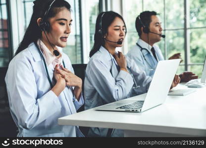 Doctor team wearing headset talking actively on video call in hospital clinic . Concept of telehealth and telemedicine service .. Doctor team wearing headset talking actively on video call in hospital clinic