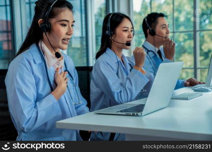 Doctor team wearing headset talking actively on video call in hospital clinic . Concept of telehealth and telemedicine service .. Doctor team wearing headset talking actively on video call in hospital clinic