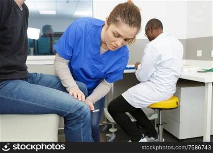 doctor testing knee reflexes with a medical hammer