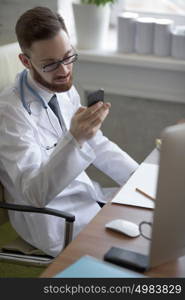 Doctor texting on his smartphone