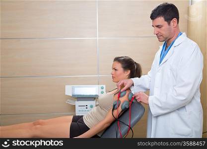 Doctor therapist checking arm shoulder muscle electrostimulation to woman in hospital