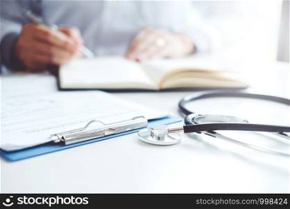Doctor typing information on Laptop in Hospital office focus on Stethoscope