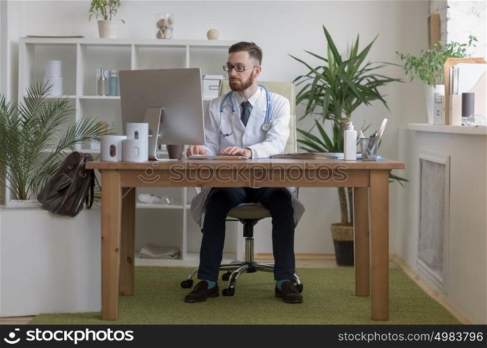 Doctor typing on his computer in the office