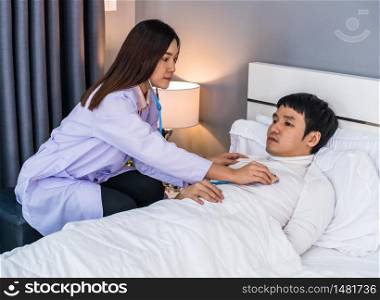 doctor use stethoscope to listen heart of male patient on a bed