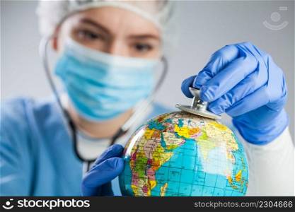 Doctor using a stethoscope to listen to the planet Earth globe and set diagnosis, global medical health check concept, COVID-19 virus disease, Coronavirus epidemic, global pandemic crisis outbreak