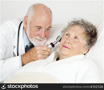Doctor using an otoscope to examine a hospital patient&rsquo;s ear canal.