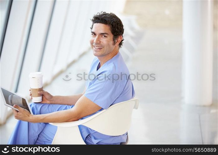Doctor Using Digital Tablet On Coffee Break In Hospital
