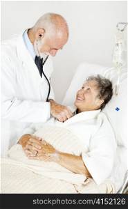 Doctor using his stethoscope to listen to an elderly hospital patient&rsquo;s heart.