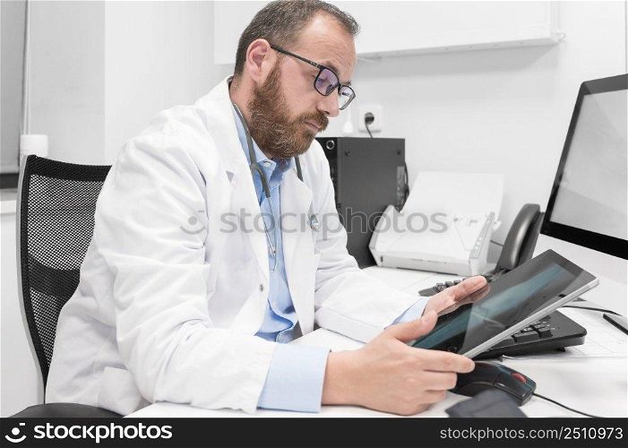 Doctor using his tablet computer at work. High quality photo. Doctor using his tablet computer at work