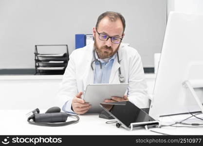 Doctor using his tablet computer at work. High quality photo. Doctor using his tablet computer at work