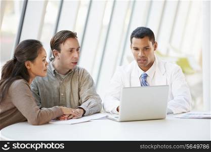 Doctor Using Laptop Discussing Treatment With Patients