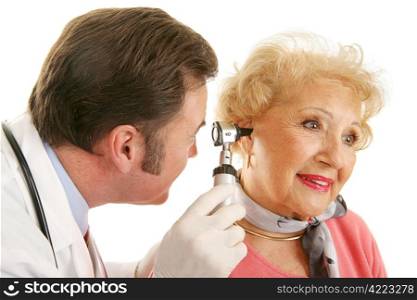 Doctor using otoscope to look inside a beatiful senior woman&rsquo;s ears. Isolated on white.