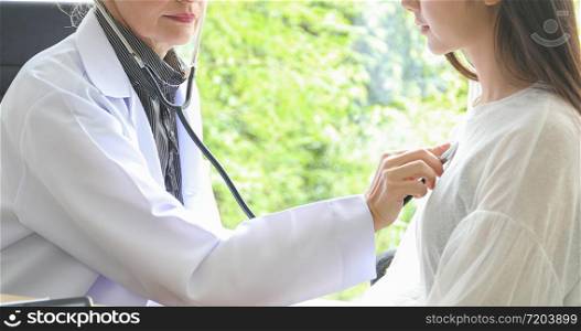 Doctor using stethoscope for examining patient in his office at Hospitals