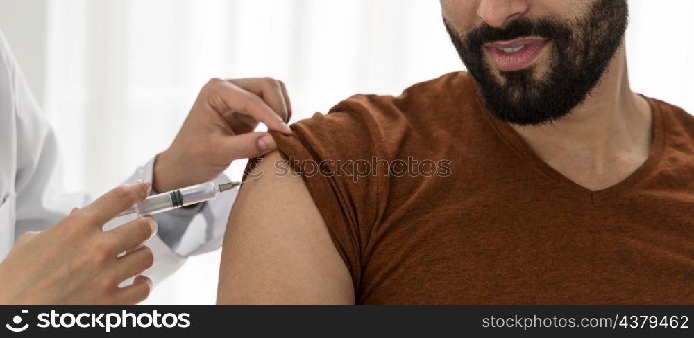 doctor vaccinating bearded man