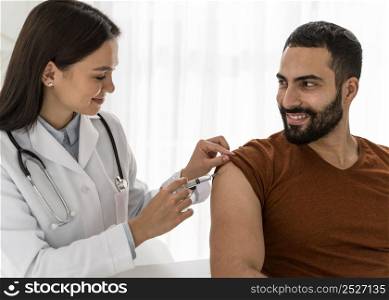 doctor vaccinating handsome man