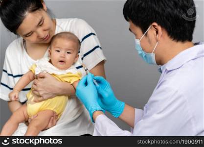 doctor vaccines or injection to baby with mother holding