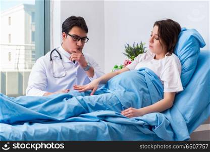 Doctor visiting pregnant in hospital room