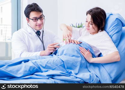 Doctor visiting pregnant in hospital room