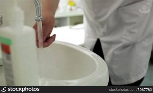 Doctor washes his hands with soap in the office