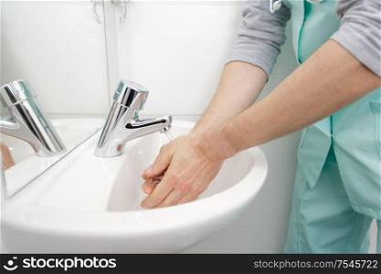 doctor washing hands at medical clinic sink