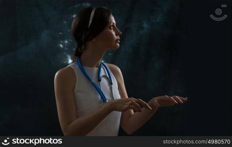Doctor wearing futuristic clothes working with virtual screen. Space background