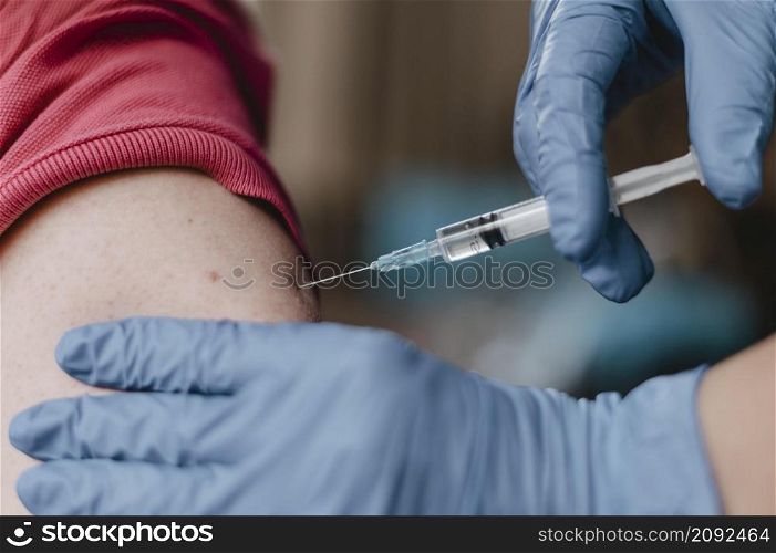 doctor wearing gloves giving child vaccine