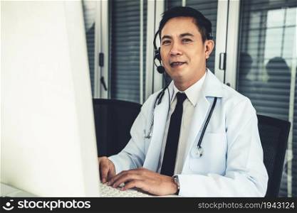 Doctor wearing headset talking actively on video call in a clinic or hospital . Concept of telehealth and telemedicine service .. Doctor wearing headset talking actively on video call in a clinic or hospital .