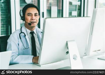 Doctor wearing headset talking actively on video call in a clinic or hospital . Concept of telehealth and telemedicine service .. Doctor wearing headset talking actively on video call in a clinic or hospital .