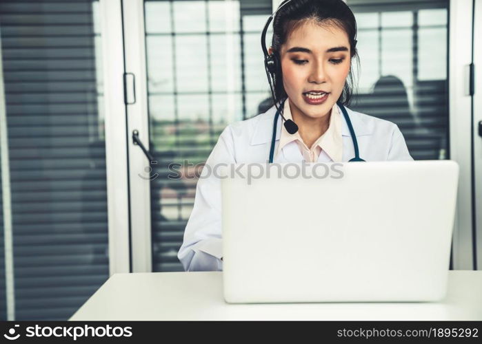 Doctor wearing headset talking actively on video call in hospital or clinic . Concept of telehealth and telemedicine service .. Doctor wearing headset talking actively on video call in hospital or clinic