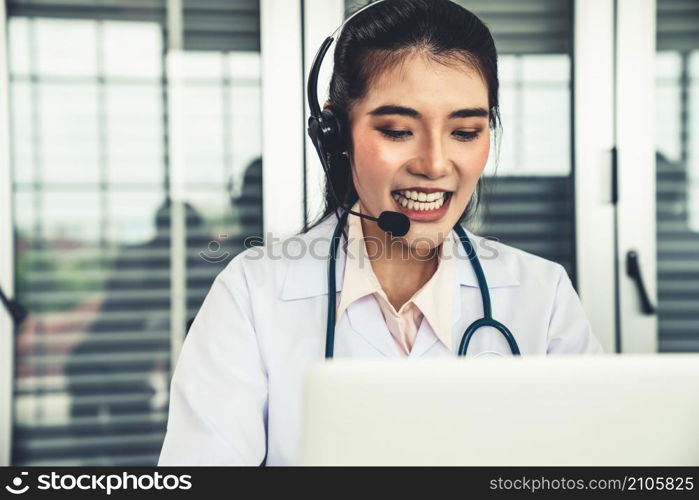 Doctor wearing headset talking actively on video call in hospital or clinic . Concept of telehealth and telemedicine service .. Doctor wearing headset talking actively on video call in hospital or clinic