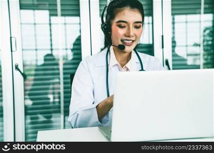 Doctor wearing headset talking actively on video call in hospital or clinic . Concept of telehealth and telemedicine service .. Doctor wearing headset talking actively on video call in hospital or clinic