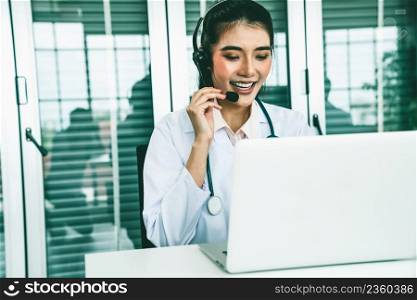 Doctor wearing headset talking actively on video call in hospital or clinic . Concept of telehealth and telemedicine service .. Doctor wearing headset talking actively on video call in hospital or clinic
