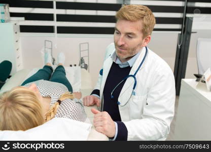 doctor with a lying woman who has a stomach ache