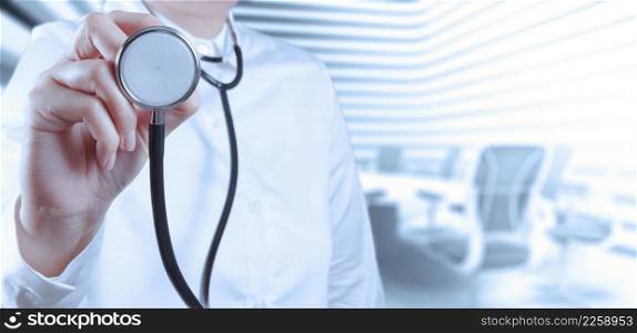 Doctor with a stethoscope in the hands and office background
