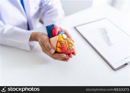 Doctor with anatomical model of human heart Cardiologist supports the heart. heart diagnose medical checkup cardiologist in examination room.