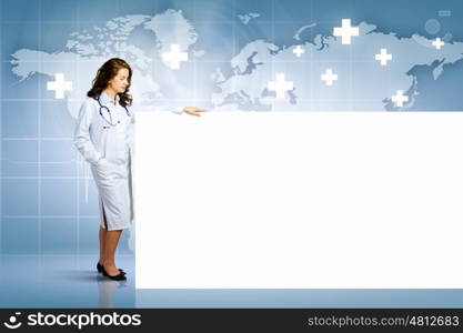 Doctor with banner. Image of young female doctor with blank banner. Place for text