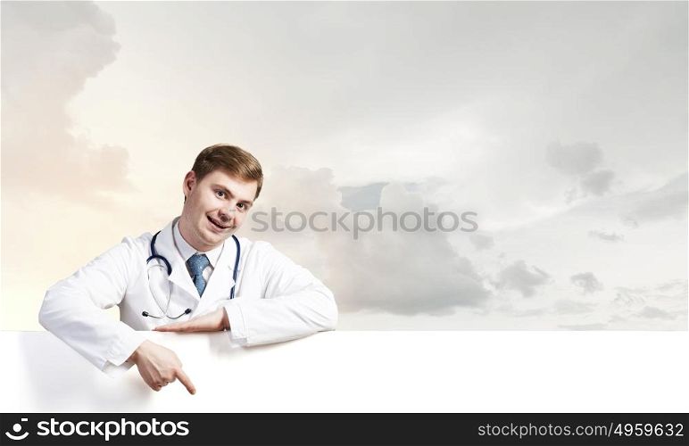 Doctor with banner. Young doctor with white blank banner. Place for text