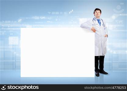Doctor with blank banner. Young male doctor with blank banner. Place for text