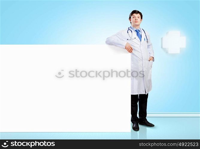 Doctor with blank banner. Young male doctor with blank banner. Place for text