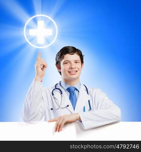 Doctor with blank banner. Young smiling doctor with blank banner. Place for text