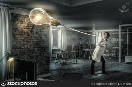 Doctor with bulb balloon. Young doctor in glasses pulling bulb balloon on rope